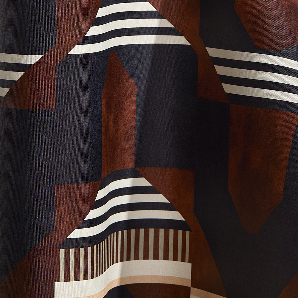 Wallpaper in a graphic geometric design in burn siena, black, taupe and cream.