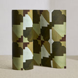 Wallpaper roll in a bold abstract checkerboard pattern in brown, cream, sage and olive green.
