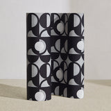 Wallpaper roll in a curvilinear art deco inspired pattern in black, grey and white.