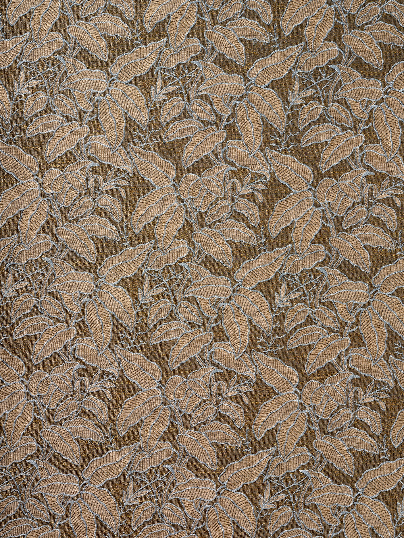 A close-up of a woven fabric pattern featuring a dense botanical leaf design in warm rust with grey outlines on a darker brown field. 