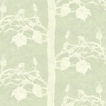 Detail of fabric in a linear tree and leaf print in cream on a light green field.