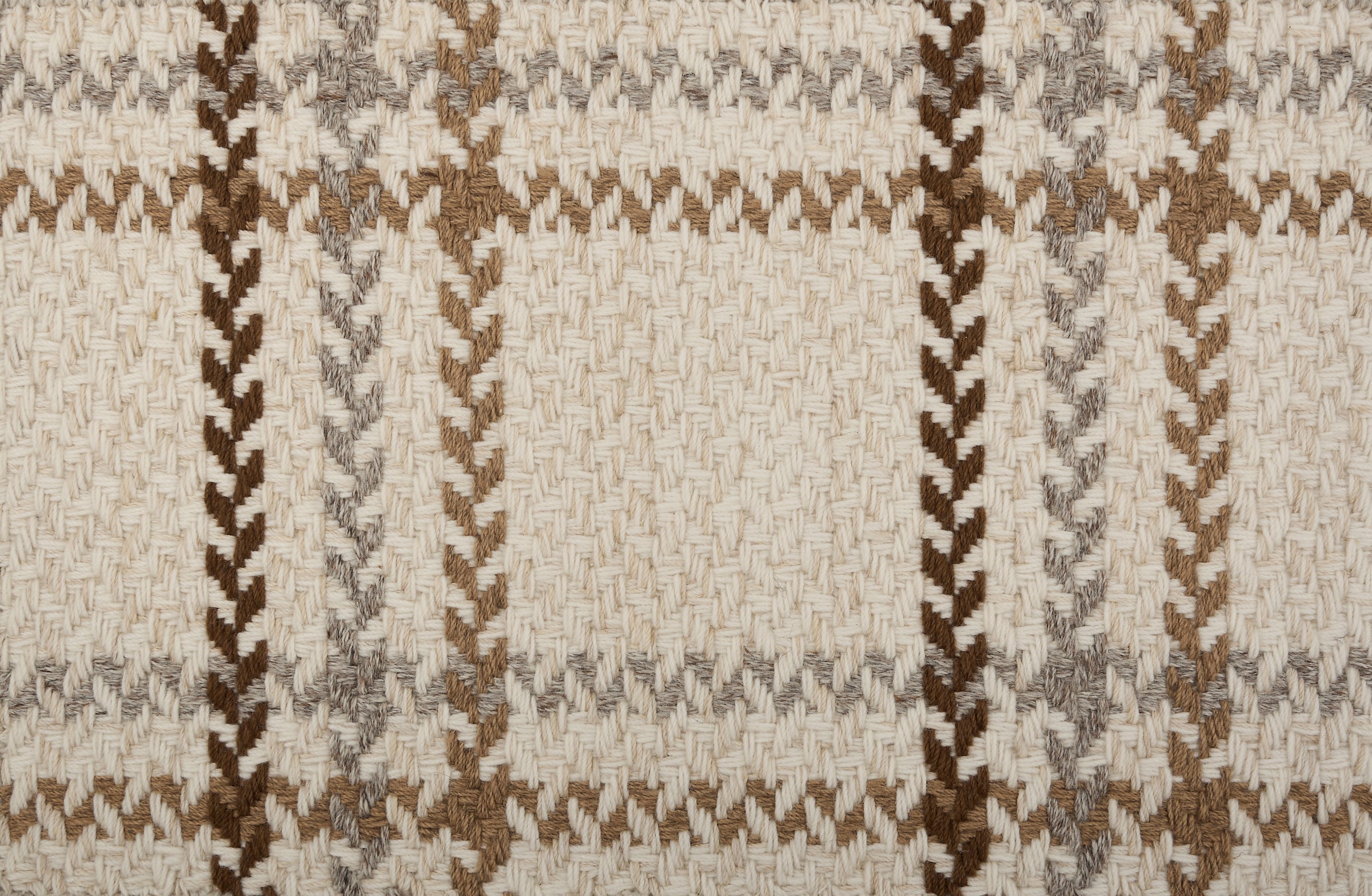 Broadloom carpet in a windowpane plaid in shades of brown on a beige field.