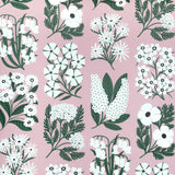 Detail of wallpaper in a minimalist floral grid print in white and green on a light pink field.