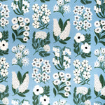 Detail of fabric in a minimalist floral grid print in white and green on a blue field.