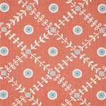 Detail of fabric in a flower and leaf lattice print in gray and white on a burnt orange field.