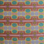 Close up of printed fabric with a complex geometric and striped pattern with pink, orange, turquoise and red. 