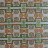 Close up of printed fabric with a complex geometric and striped pattern with orange, brown, grey and green.