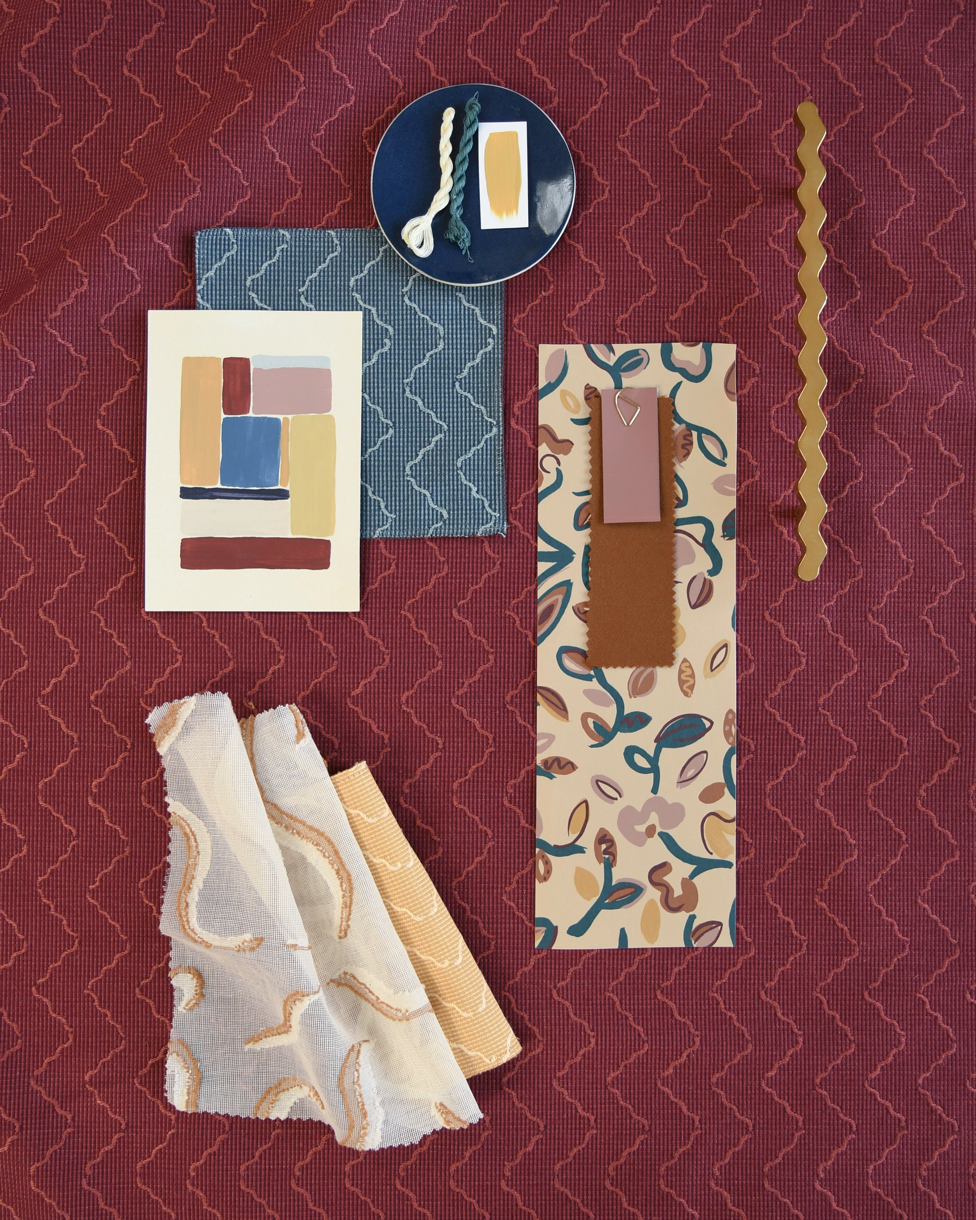 Moodboard with layered swatches of fabrics and inspiration images in palette of red, yellow and pink,