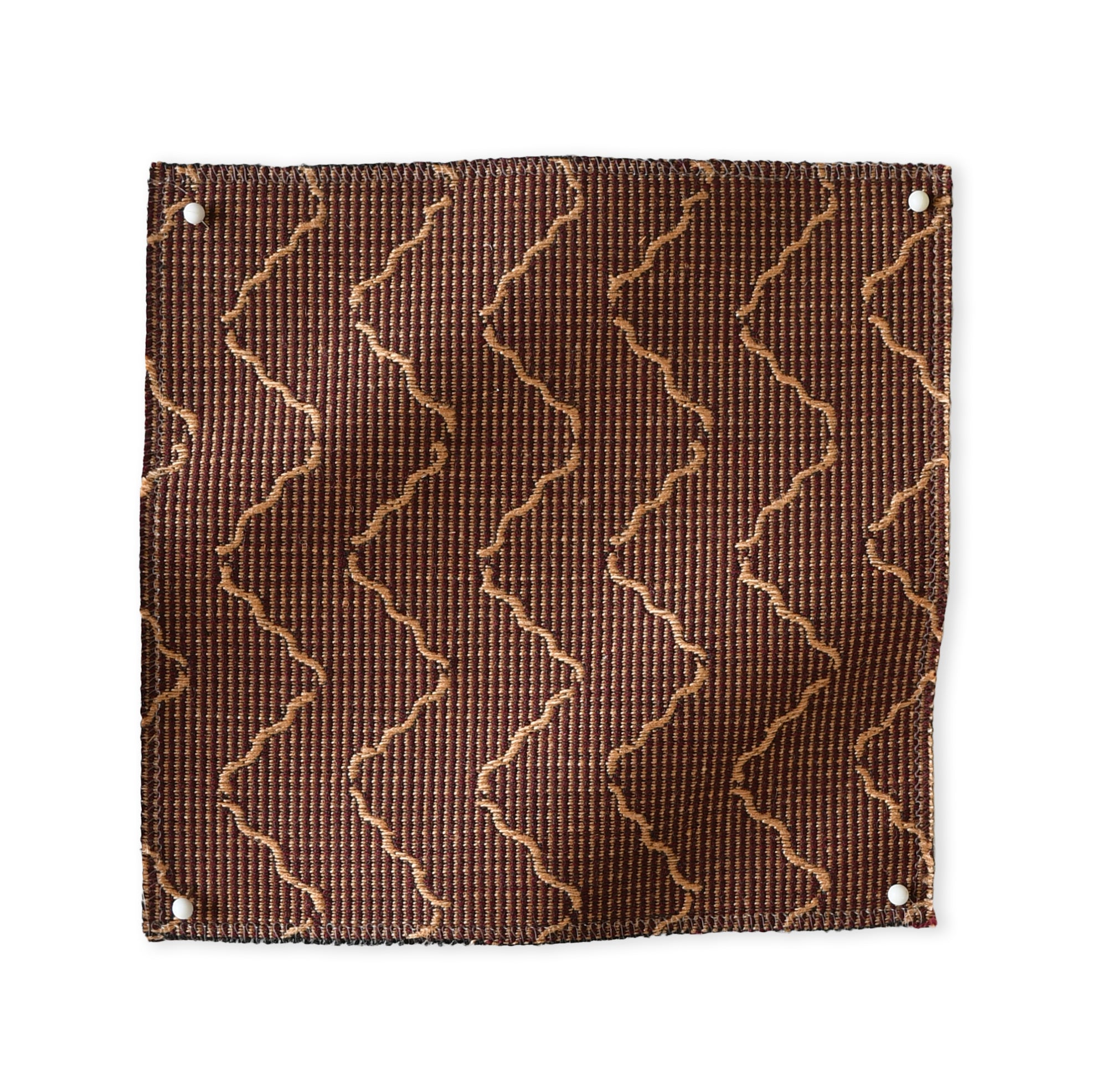 Pinned swatch of woven fabric with chevron stripe in brown