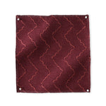 Pinned swatch of woven fabric with chevron stripe in dark red. 