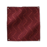 Pinned swatch of woven fabric with chevron stripe in dark red. 