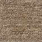 A close-up of a handknotted rug with a textural loop weave in natural allo fibre. 