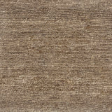 A close-up of a handknotted rug with a textural loop weave in natural allo fibre. 