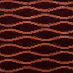 Hand knotted rug with a wavy line in orange on a maroon field. 