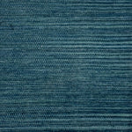 A close-up of a handwoven carpet in a heathered teal colorway. 