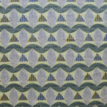 A close-up of a patterned fabric featuring repeating rows of stylized grey leaves, blue and yellow stripe triangles and wavy blue-yellow lines on yellow background.