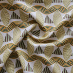 A close-up of a gently draped patterned fabric featuring repeating rows of stylized tan leaves, brown and green striped triangles and wavy tan-green lines on a white background