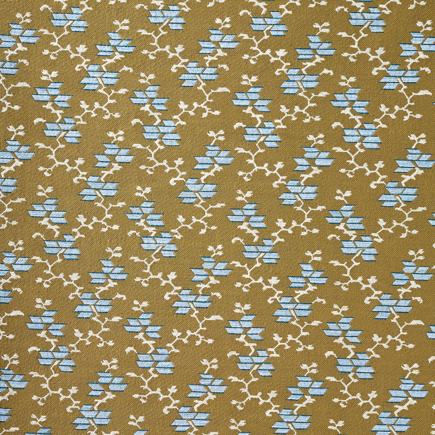 A close-up of a woven fabric pattern featuring a repeating geometric design of light blue diamond floral shapes and cream branch motifs on a warm tan background.