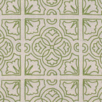 Detail of fabric in a damask lattice print in green on a tan field.