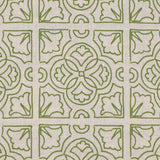 Detail of fabric in a damask lattice print in green on a tan field.