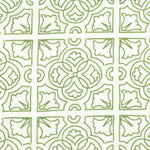 Detail of fabric in a damask lattice print in green on a white field.