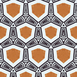 Detail of fabric in a geometric tribal print in shades of gold and black on a white field.