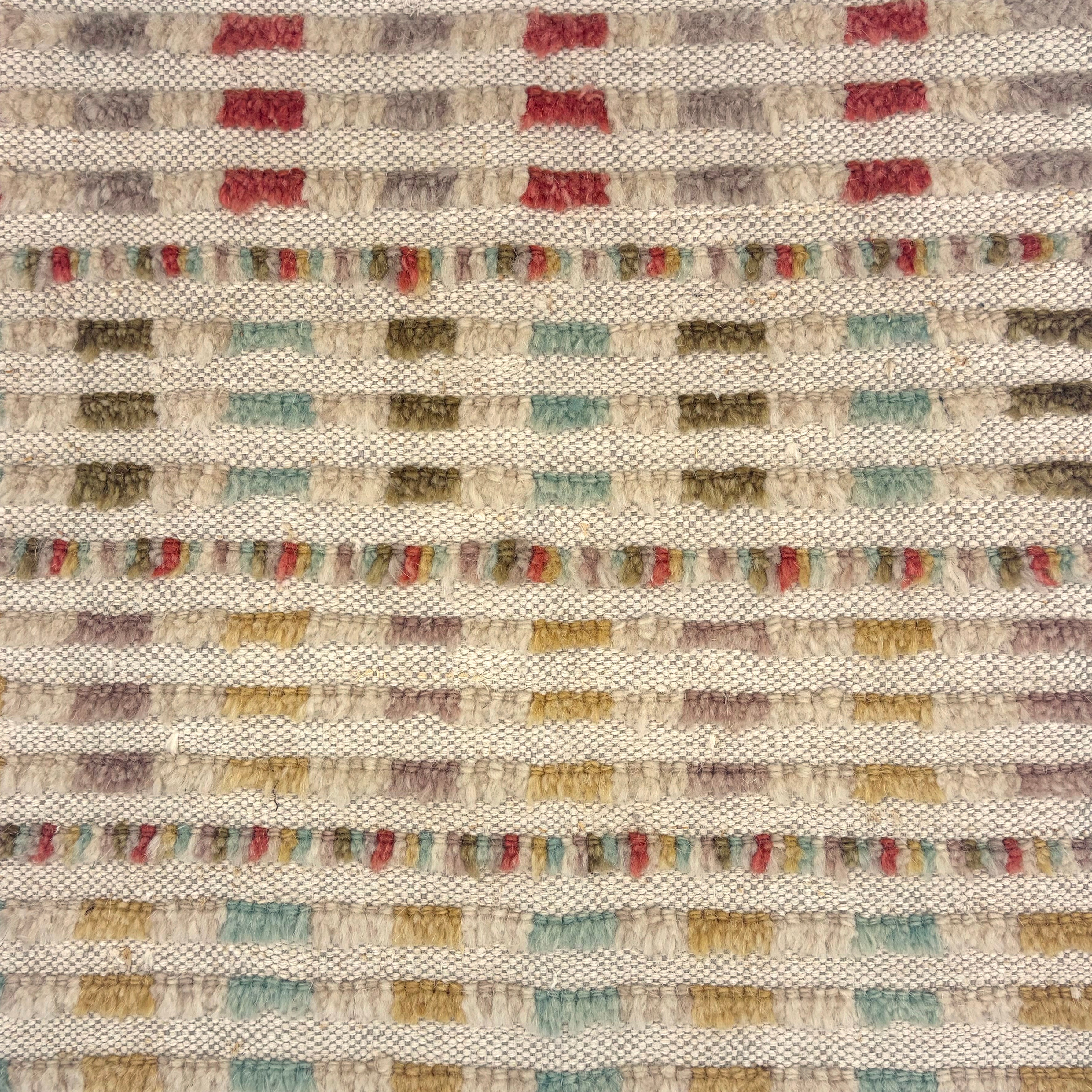 Handwoven wool rug with raised fringe multicolor stripes in pink, purple, cream green, turquoise and yellow on a beige field.