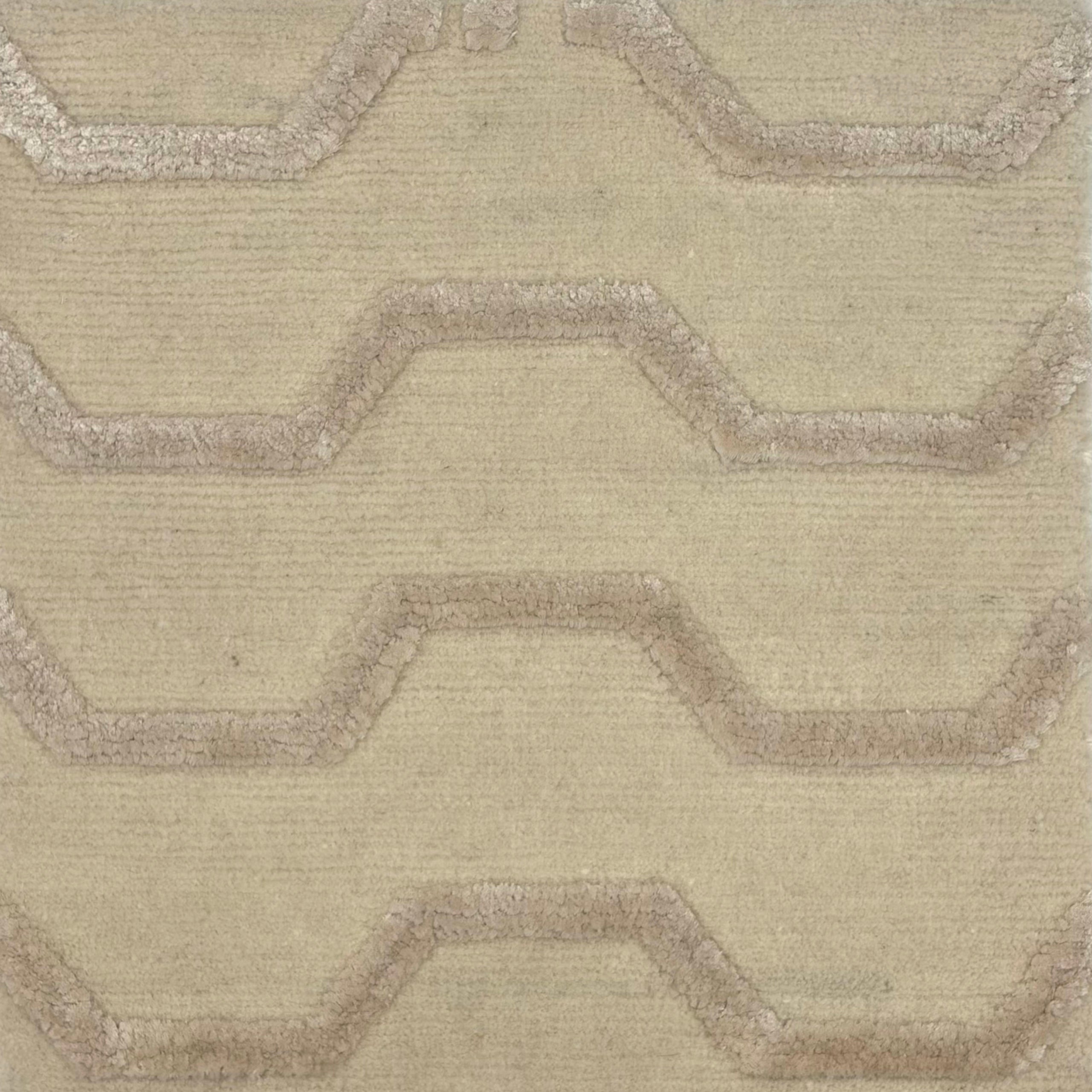 Tonal cream handknotted rug with a raised silk geometric zigzag pattern in on a solid wool cut pile ground. 
