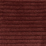 Close up of a shag stripe carpet in deep red. 