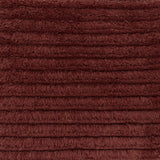 Close up of a shag stripe carpet in deep red. 