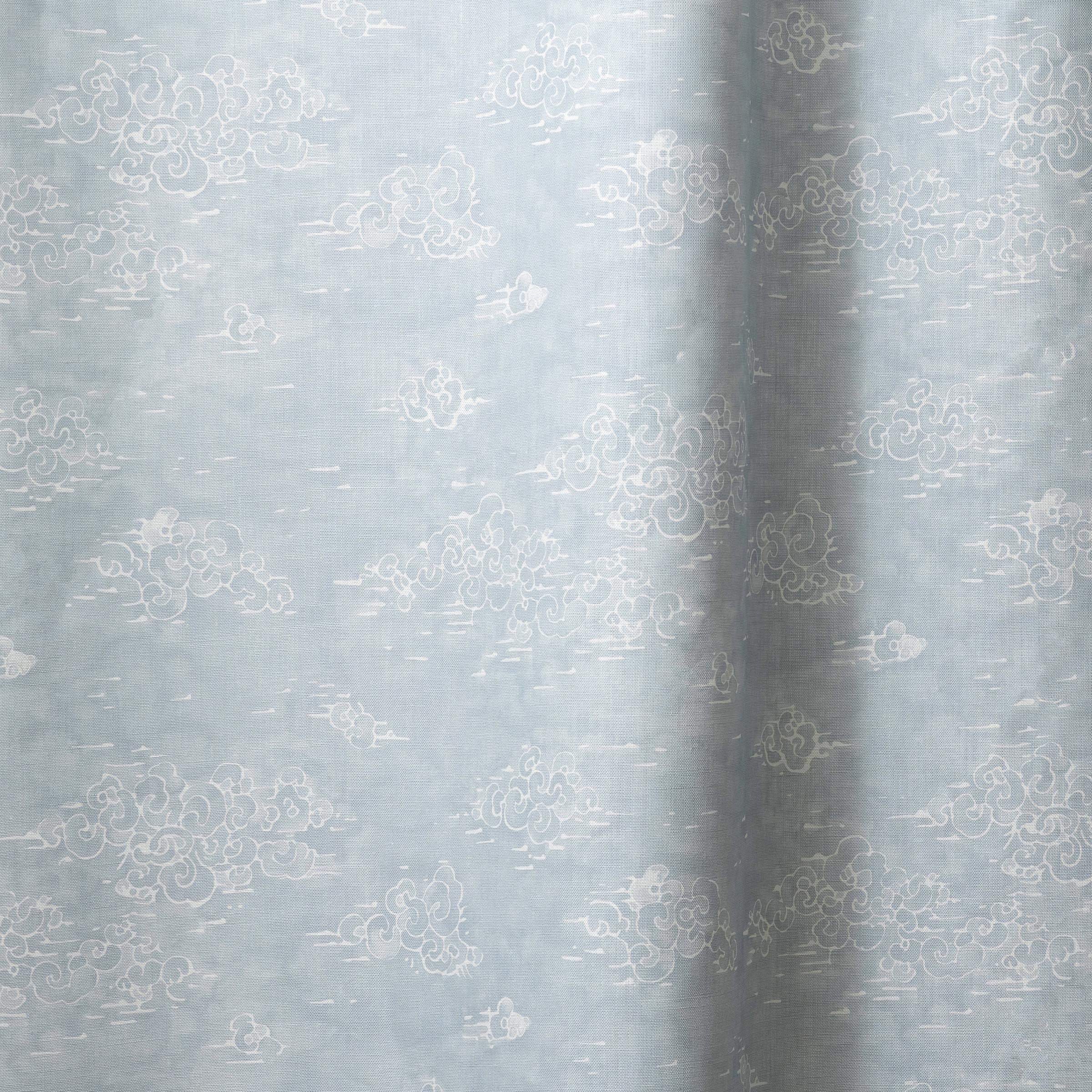 Draped fabric a painterly cloud pattern in white on a pastel blue watercolor field.