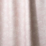 Draped fabric a painterly cloud pattern in white on a pastel pink watercolor field.