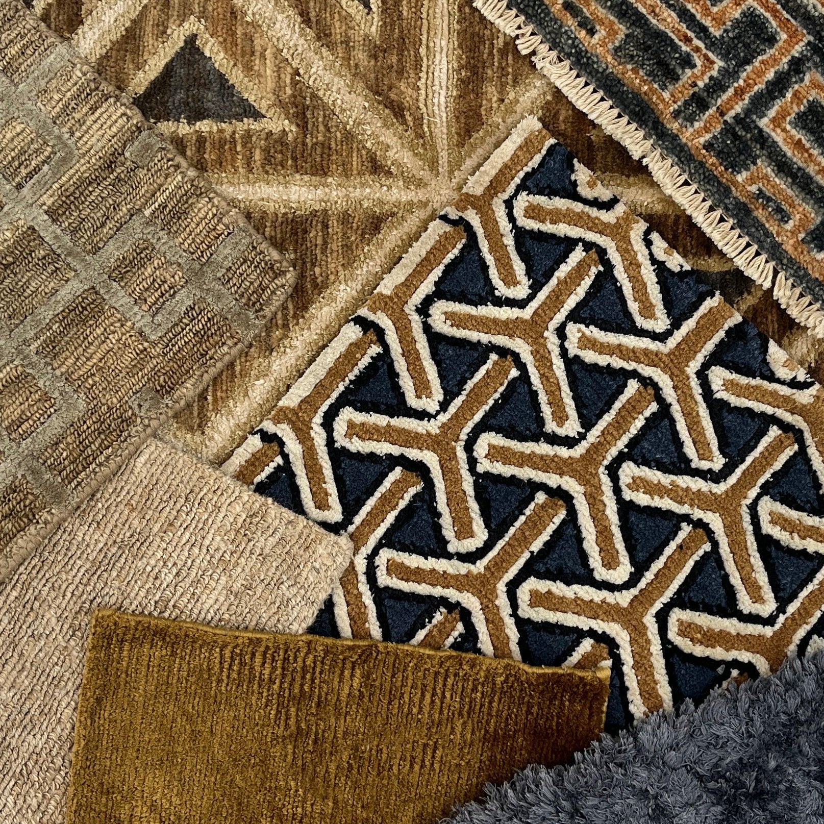Styled flat lay image with handmade rugs in geometric patterns and solid textures in navy blue, taupe and beige. 