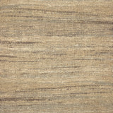 A close-up of a woven rug with a subtle striped texture in natural tan, beige, and brown tones.