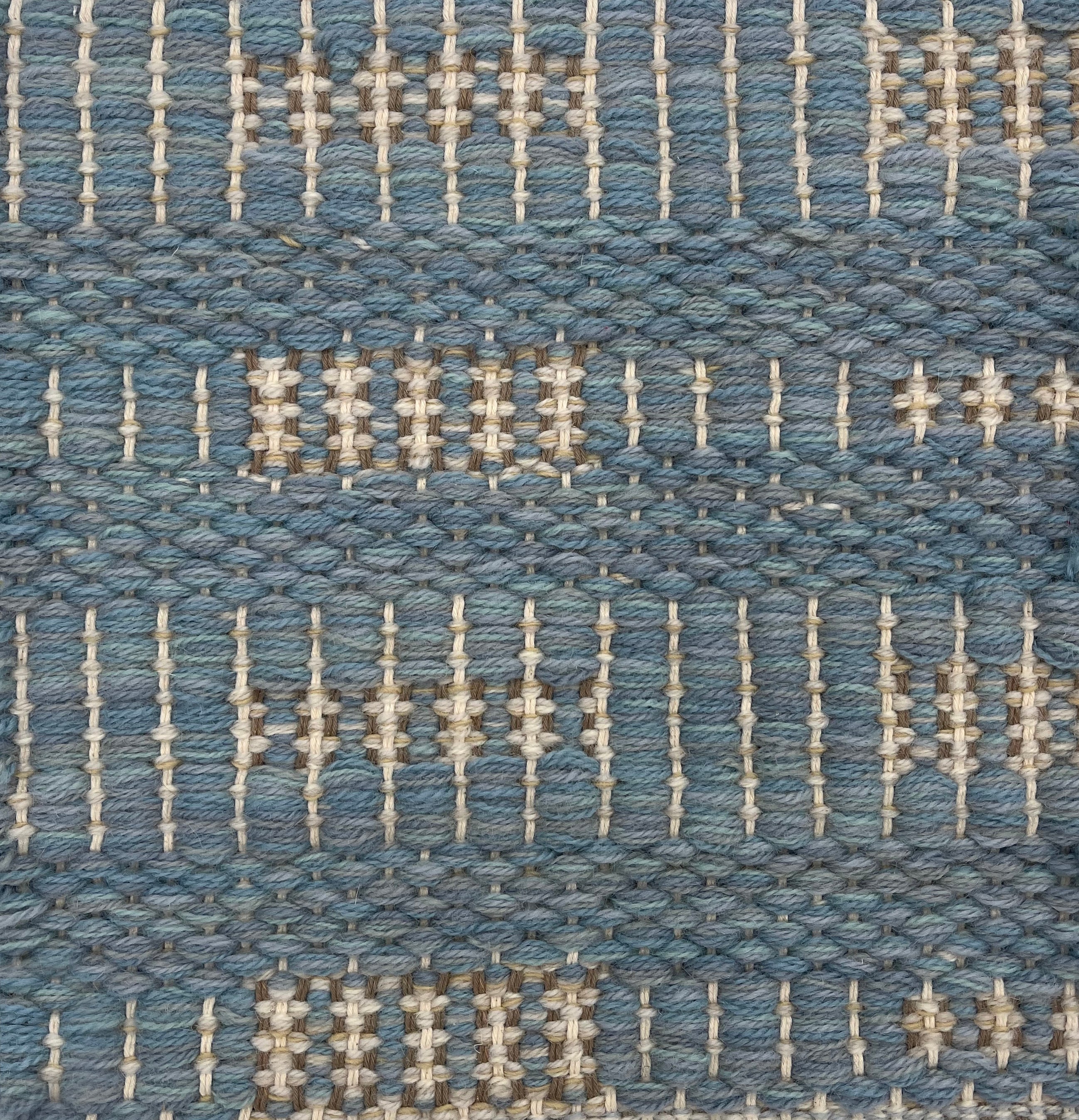 Handwoven rug detail in a contemporary striped design in blue, and cream