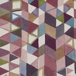 Detail of fabric in a playful repeating geometric print in shades of pink, purple, cream and green.
