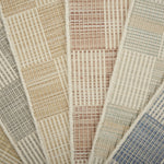 Stack of broadloom samples in a checkerboard pattern in cream and pastel hues.