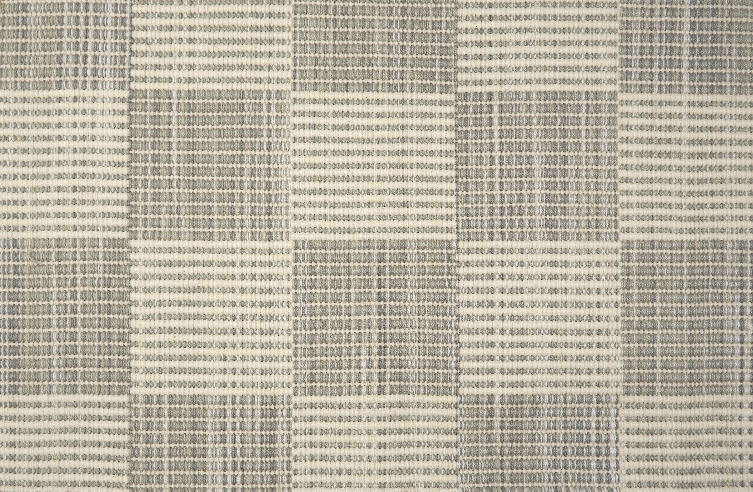 Broadloom carpet in a ribbed checkerboard pattern in cream and grey.