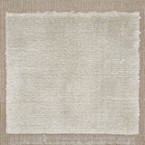 Handloomed rug with neutral border and raised cut pile shag field in cream.