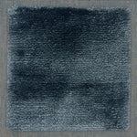 Handloomed rug with tonall border and raised cut pile shag field in dark blue.
