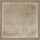 Handloomed rug with neutral border and raised cut pile shag field in taupe. 