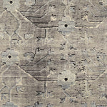 A rug with an overall flower and vine pattern in shades of pale grey, taupe, ivory, and black.