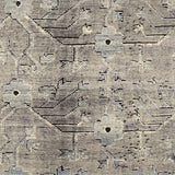 A rug with an overall flower and vine pattern in shades of pale grey, taupe, ivory, and black.