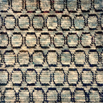 Detail of a handknotted custom rug in blue and navy with a circle pattern