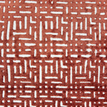 Handknotted rug sample with a geometric lattice pattern in rust red on a white field.