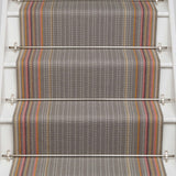 Striped flatweave runner in grey with pink orange and tan on white staircase