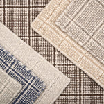 Close-up of various textured rug samples with plaid pattern in neutral colors.