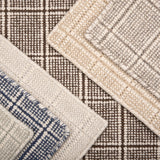 Close-up of various textured rug samples with plaid pattern in neutral colors.