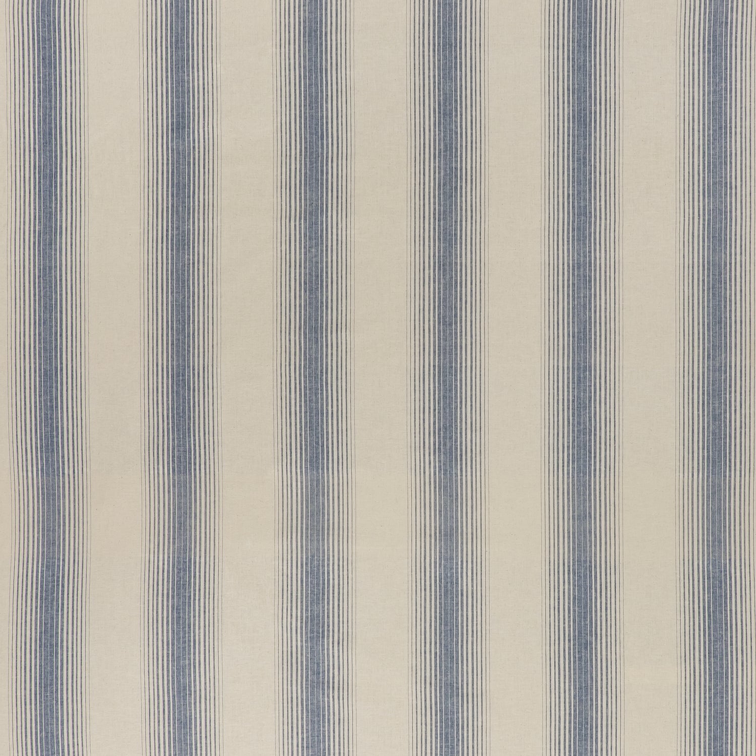 printed cotton fabric in an irregular stripe pattern in blue on a cream field.
