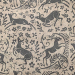 Detail of wallpaper in a deer, leaf and flower print in gray on a mottled tan field.